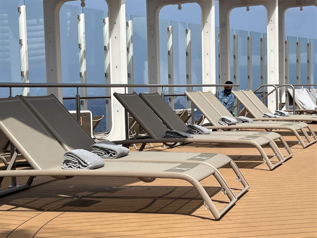 Chairs on deck Celebrity Edge spaced 6 feet apart around pool